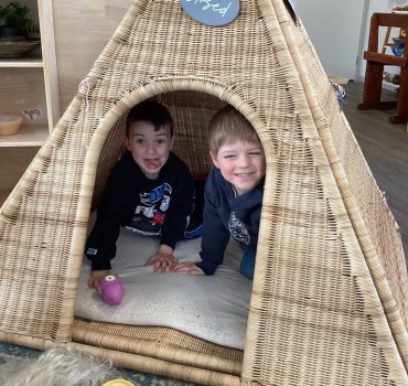 Two children playing in a woven cubby at Romsey Early Learning